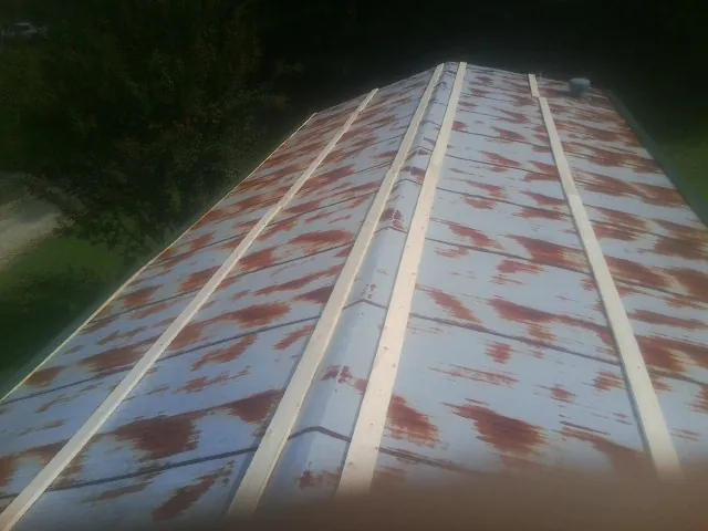 Rusted metal roof panels with new wood purlins before replacement — Storm Damage Roof Repair in Ayer by Roofing Brothers