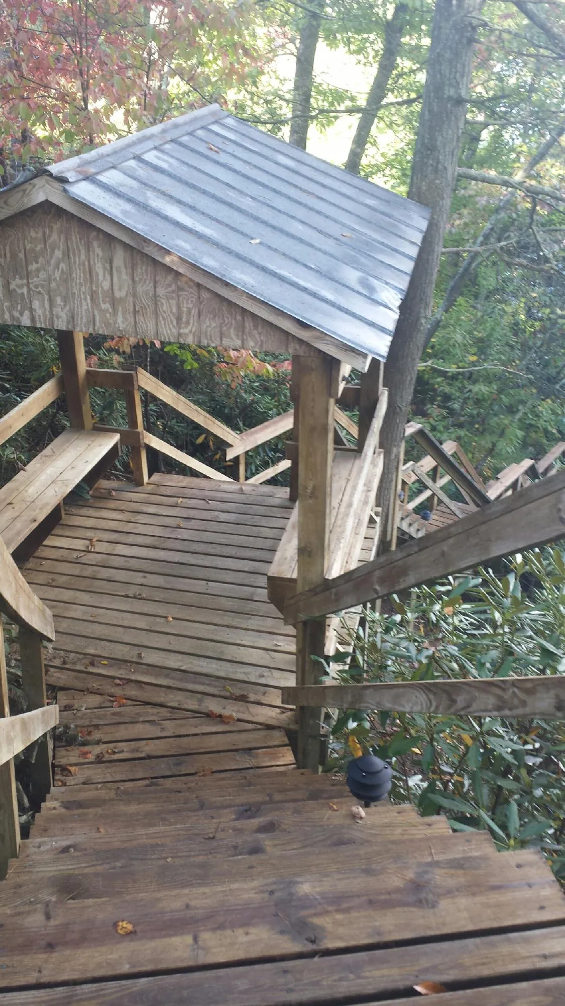 Metal roofed shelter over wooden steps on a wooded walkway — Skylight Repair & Installation work by our crew in Ayer
